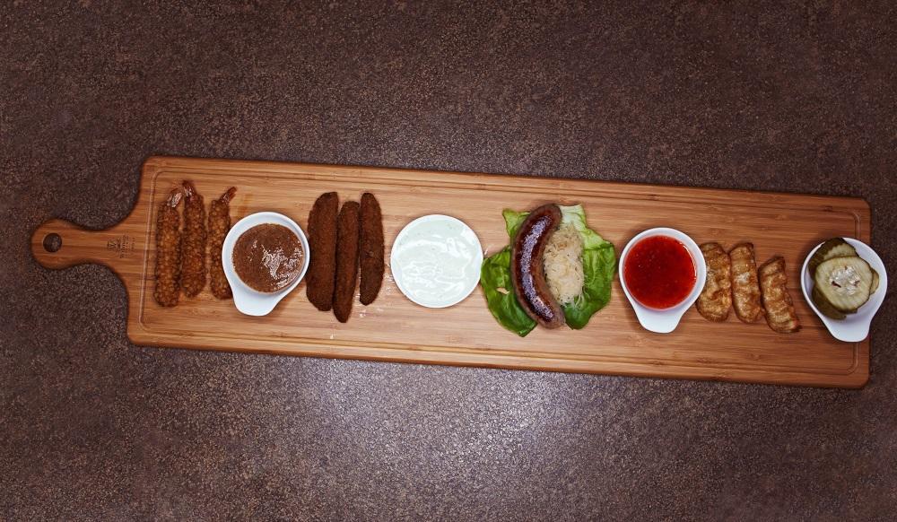 A stylish bamboo charcuterie board with a handle, perfect for serving appetizers and sides, showcasing its natural texture and elegant design.