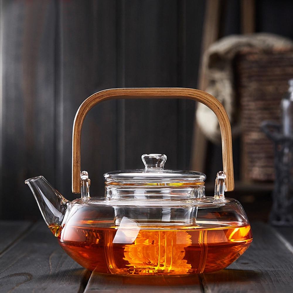 A stylish Bamboo & Glass Tea Kettle featuring an ergonomic handle and removable infuser, perfect for brewing loose-leaf tea.