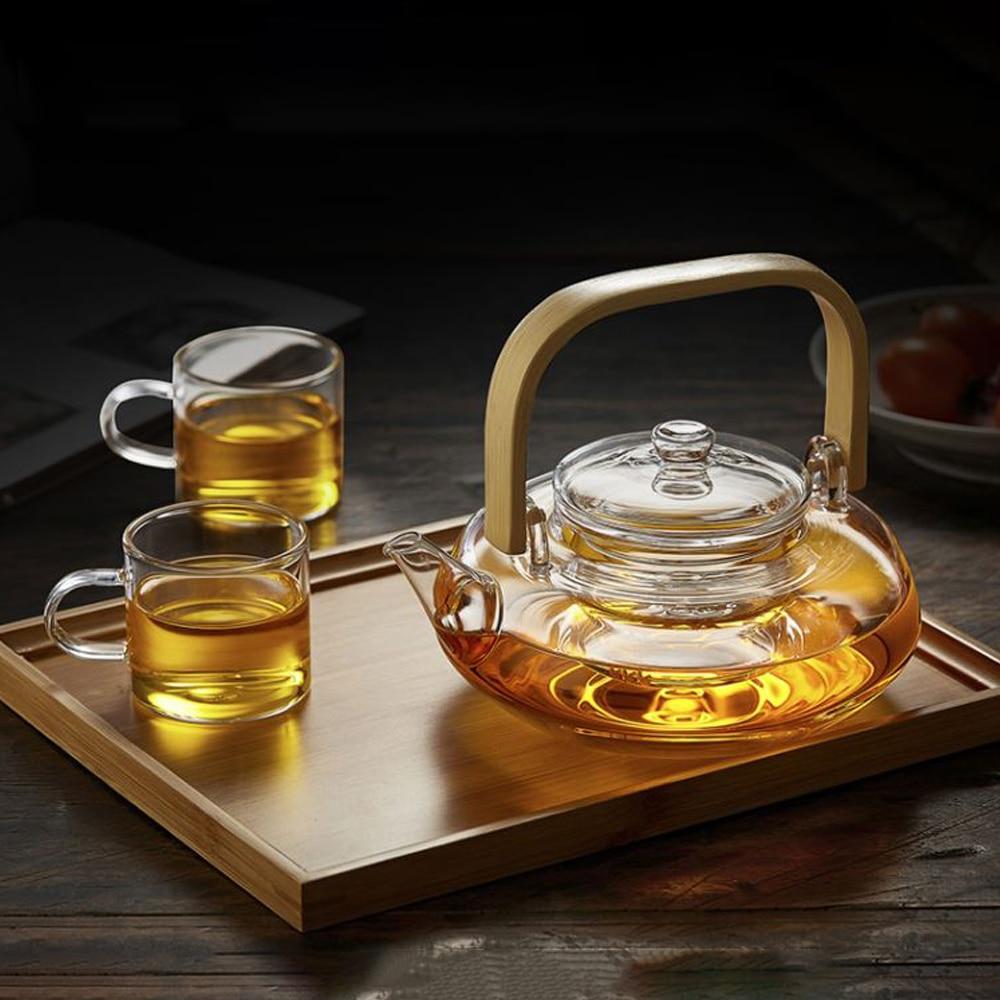 A stylish Bamboo & Glass Tea Kettle featuring an ergonomic handle and removable infuser, perfect for brewing loose-leaf tea.