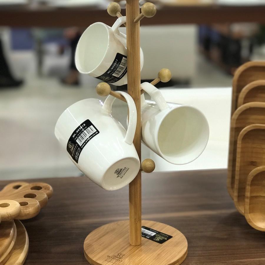 A stylish bamboo mug tree displaying multiple mugs, featuring a round base and two pegs for secure storage.