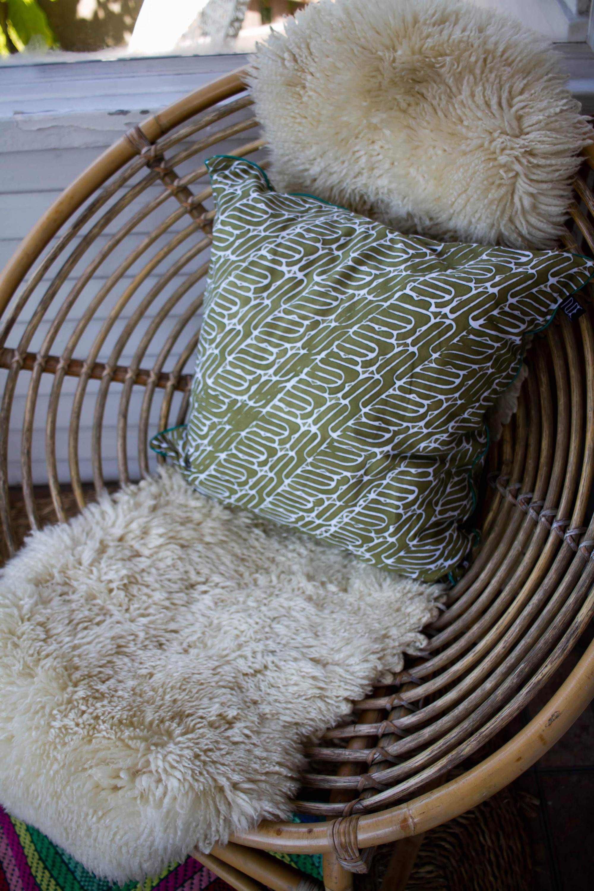 Olive green batik pillow with intricate traditional designs, handwoven and perfect for home decor.