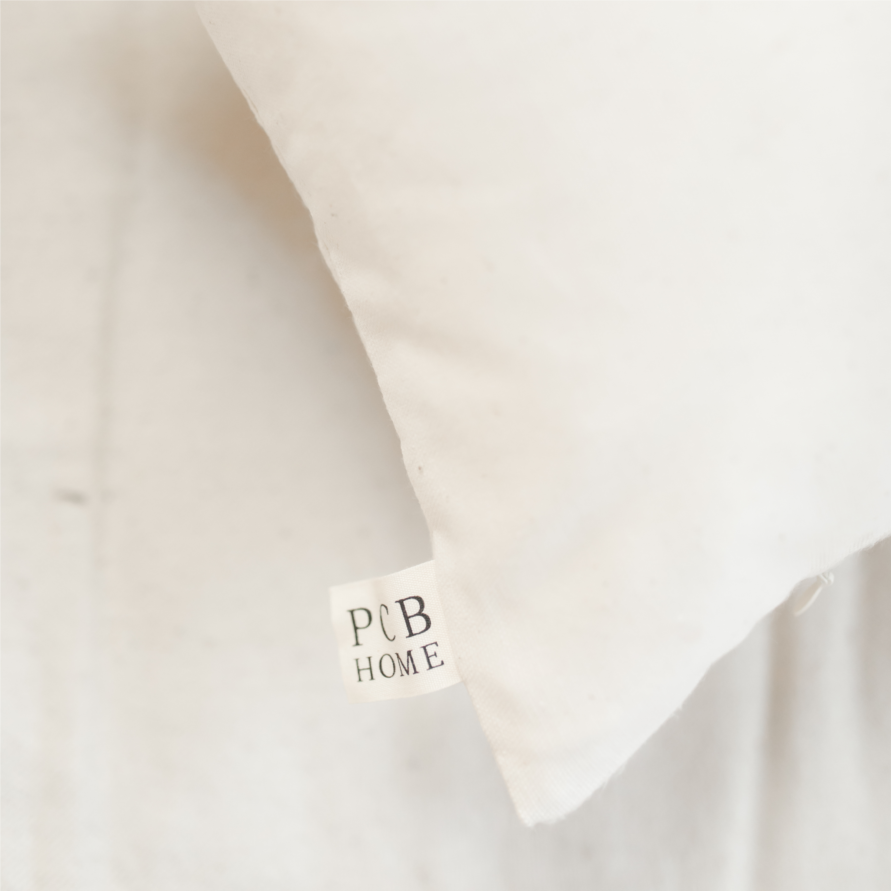 Be Still Verse Pillow featuring unique calligraphy designs on soft cotton fabric, available in white and natural colors.