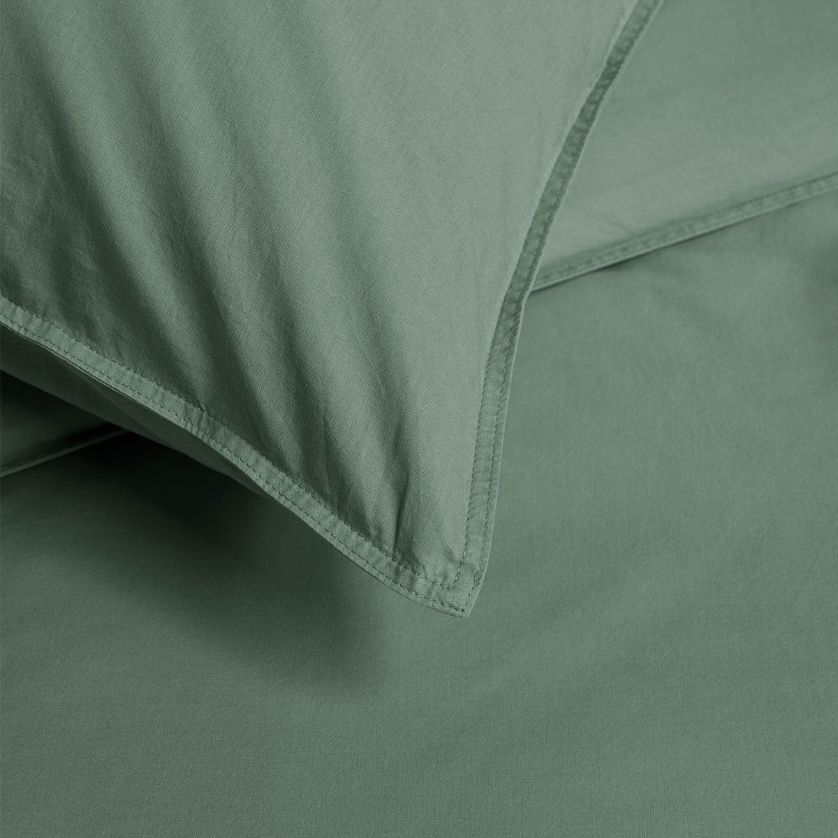 Bedding House Organic Cotton Basic Green Quilt Cover Set displayed on a bed, featuring a solid green color and soft texture.