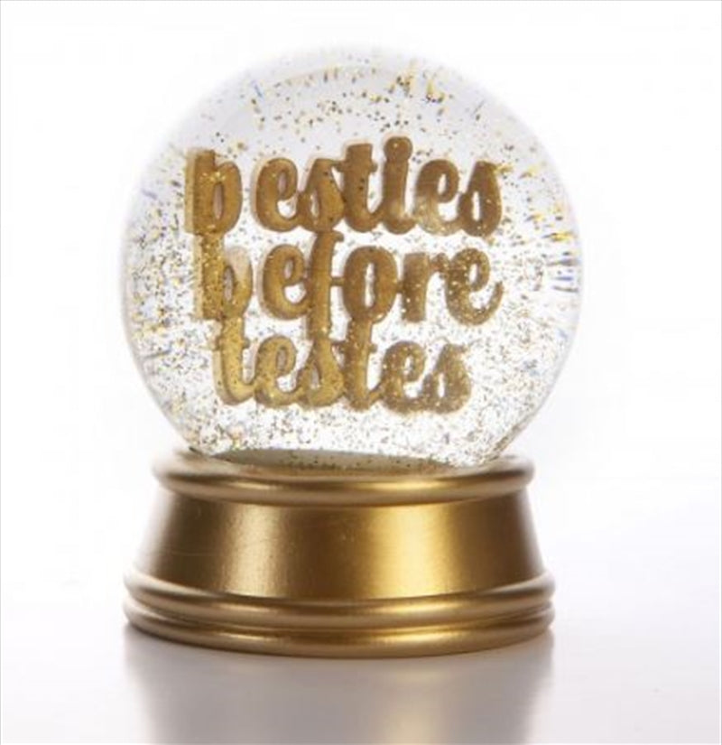 A glamorous snow globe ornament featuring gold text 'Besties before testes' with twinkling gold glitter inside.