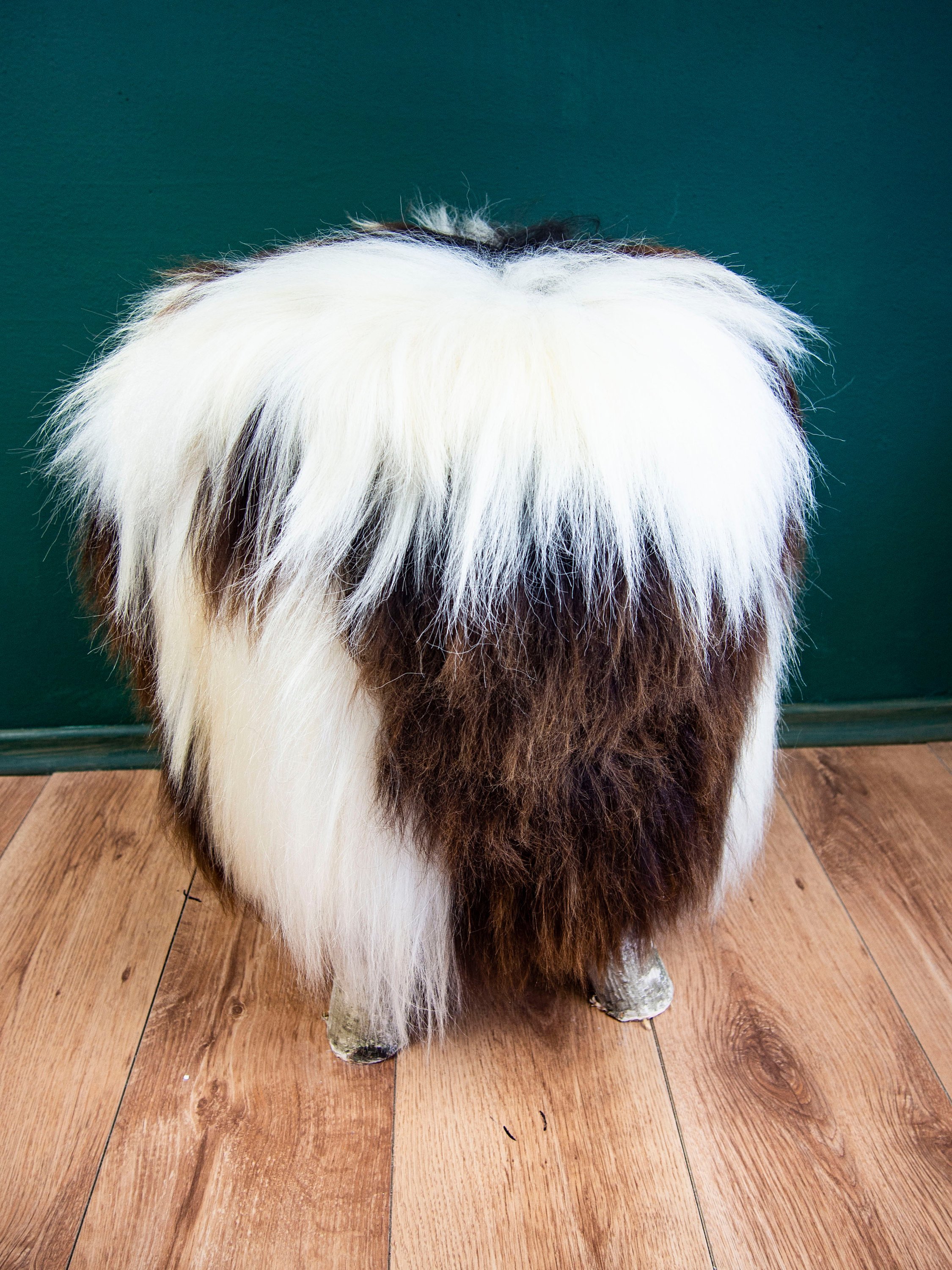 Birch wood ottoman upholstered with fluffy Jacob sheepskin, showcasing its elegant design and natural materials.