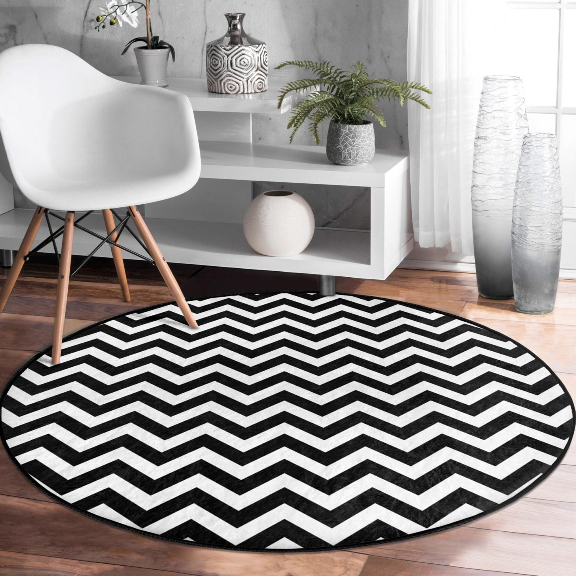 A stylish black and white round living room rug made of soft velvet fabric, showcasing a modern design suitable for various home decor styles.