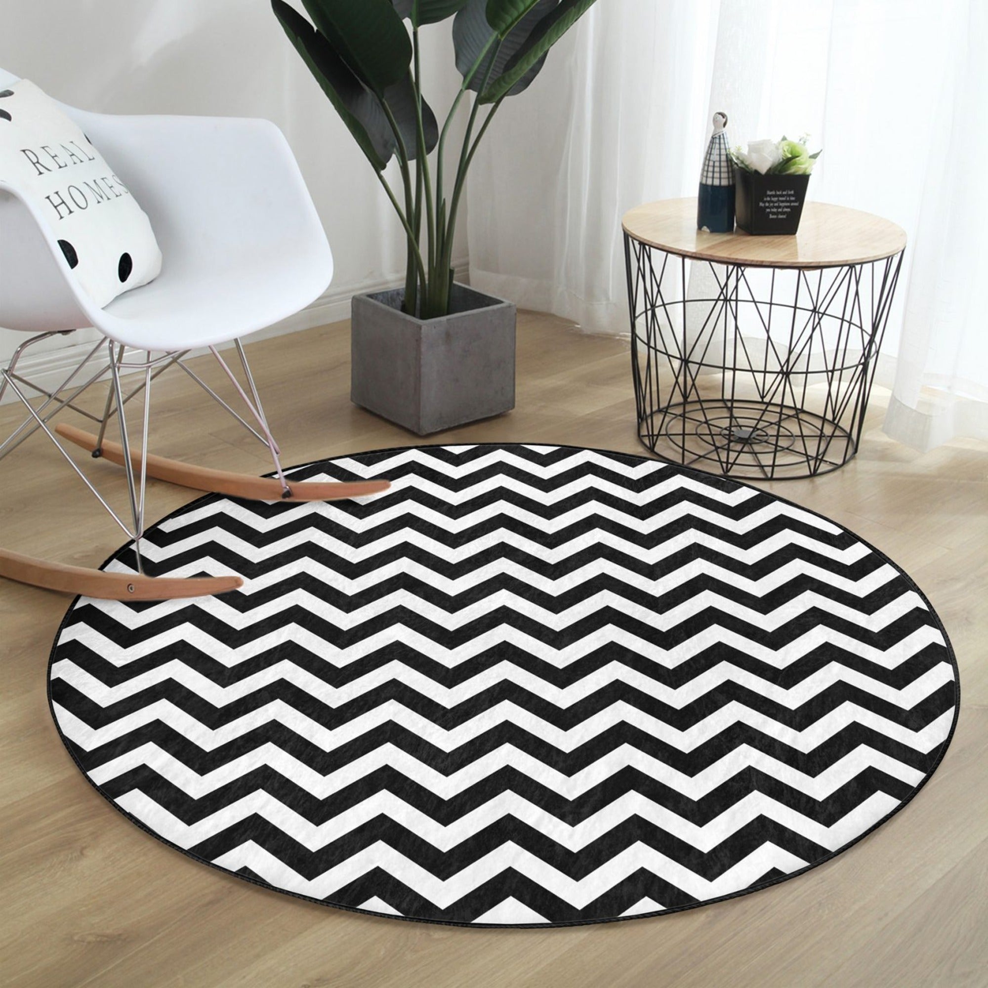 A stylish black and white round living room rug made of soft velvet fabric, showcasing a modern design suitable for various home decor styles.