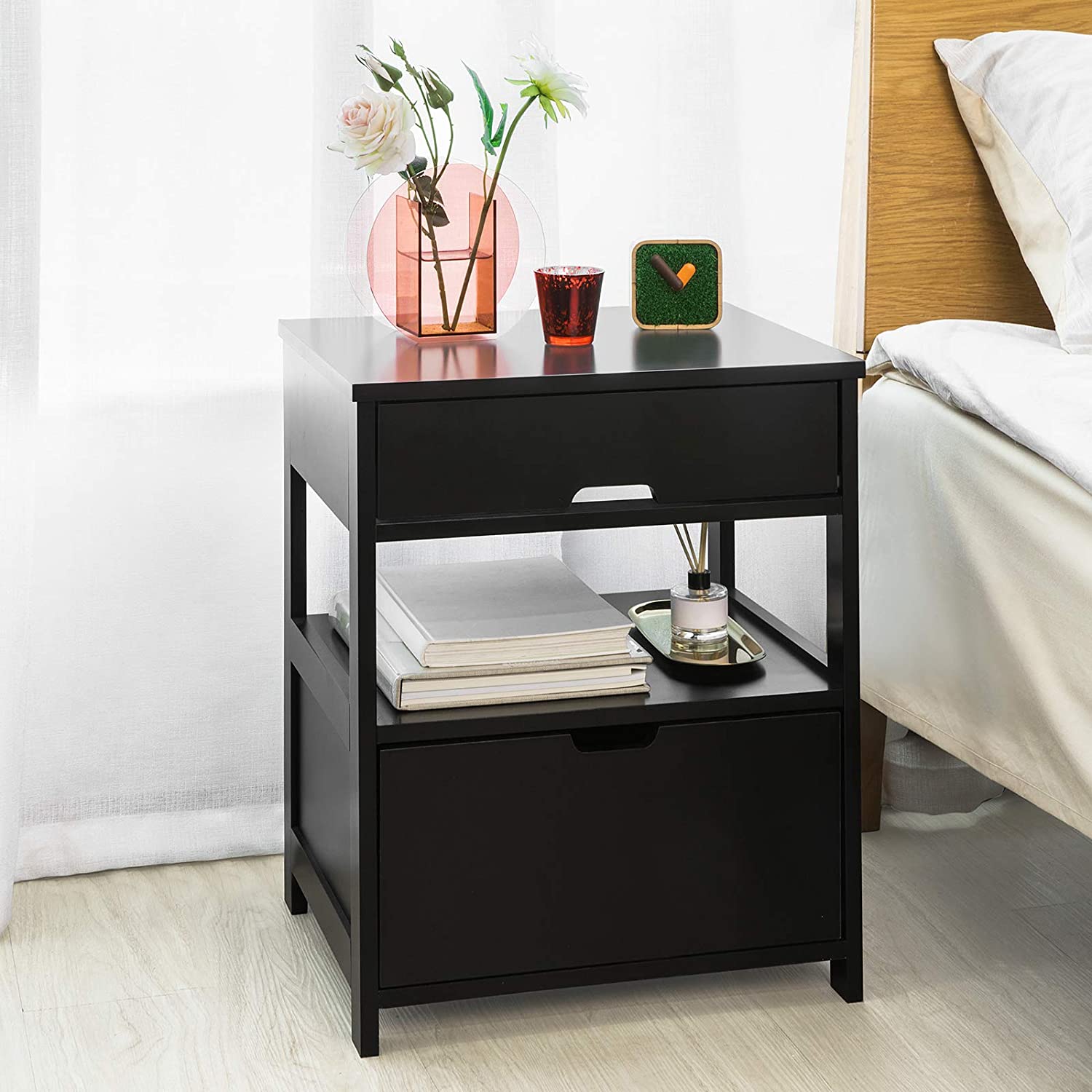 Black bedside table featuring two drawers and a shelf, designed for modern decor.