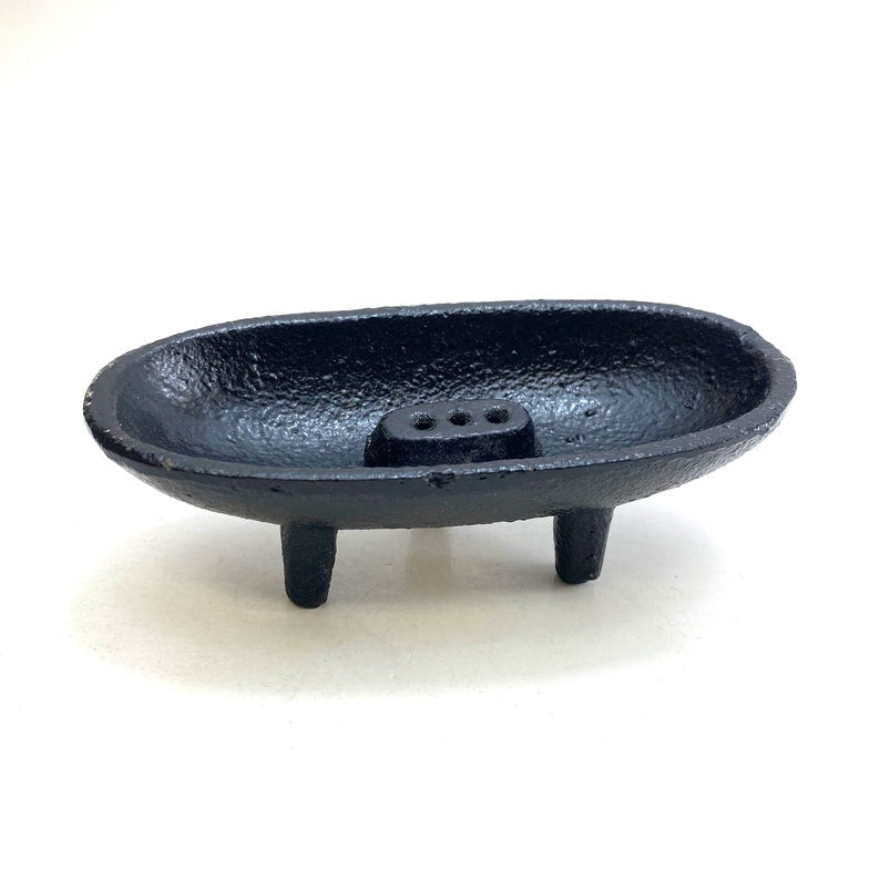 Black cast iron canoe-shaped incense smudge pot with removable holder for incense sticks and cones.