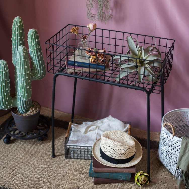 Black metal plant stand showcasing a modern design, perfect for indoor and outdoor use.