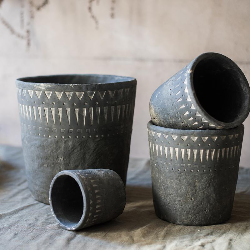 A stylish black pottery cement planter in various sizes, showcasing its modern design and durability.