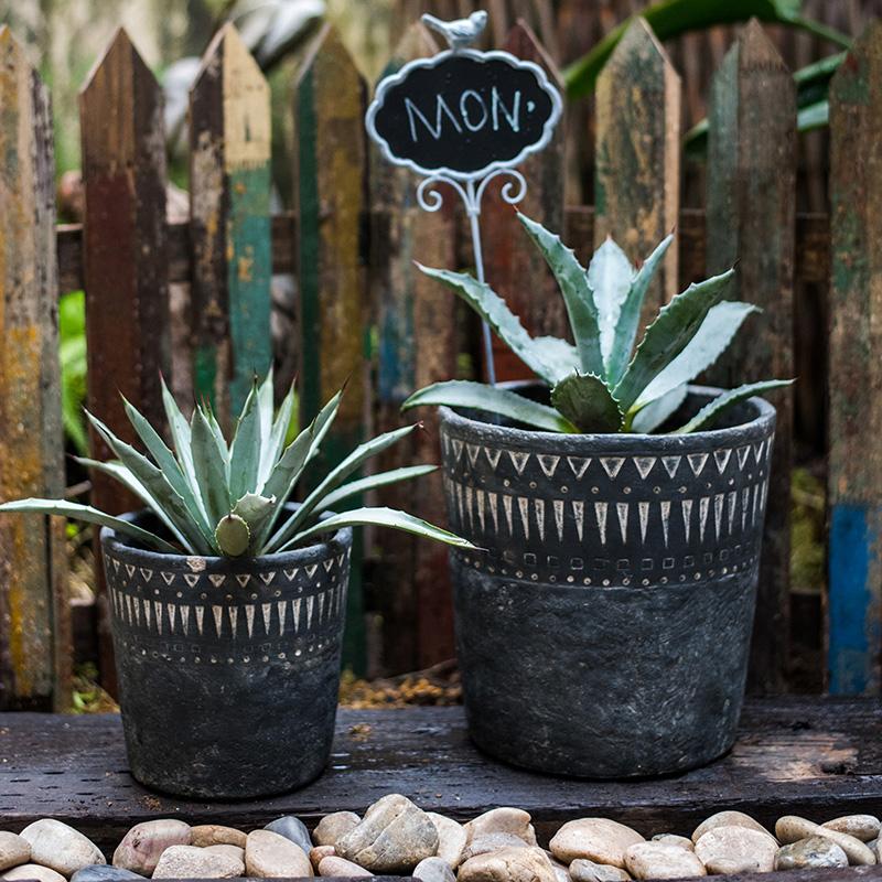 A stylish black pottery cement planter in various sizes, showcasing its modern design and durability.