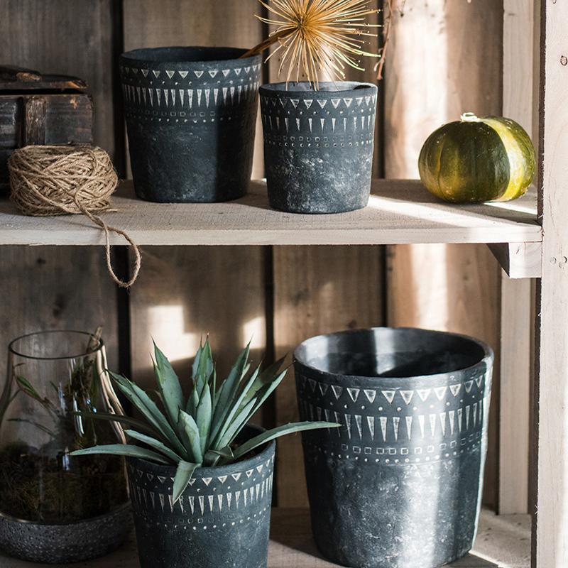 A stylish black pottery cement planter in various sizes, showcasing its modern design and durability.