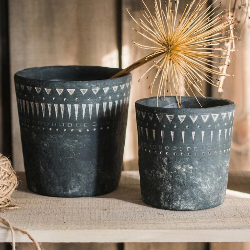 A stylish black pottery cement planter in various sizes, showcasing its modern design and durability.