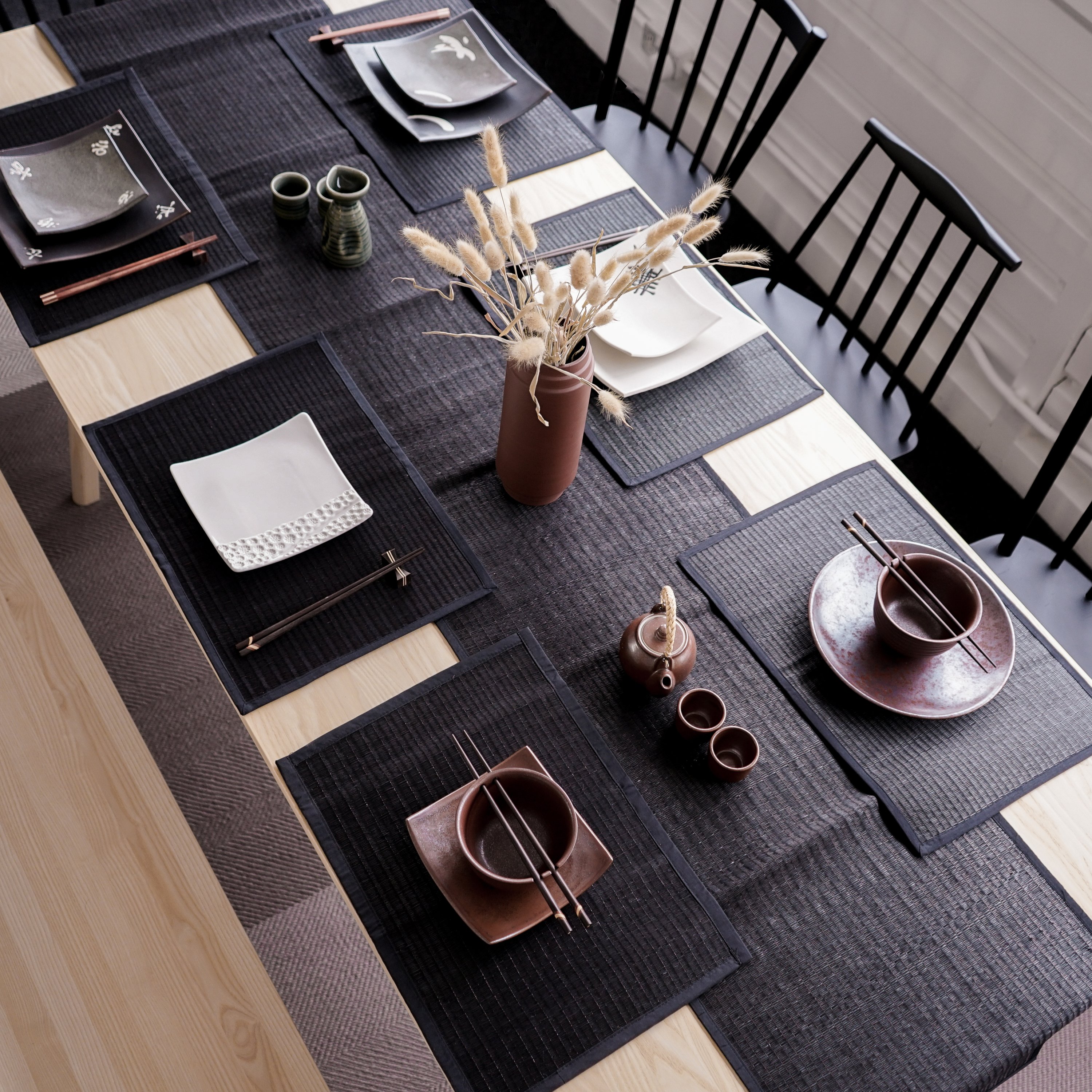 Elegant Black Reed Table Runner on a dining table, showcasing its handmade texture and cotton trim.