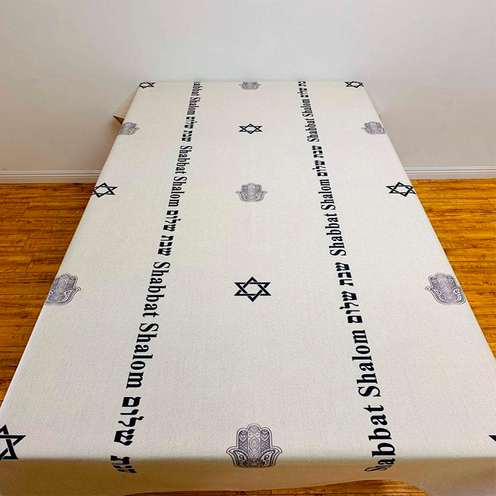 Elegant Black Shabbat Shalom tablecloth featuring Hebrew and English stripes, Magen David and Hamsa details, made from linen-cotton blend.