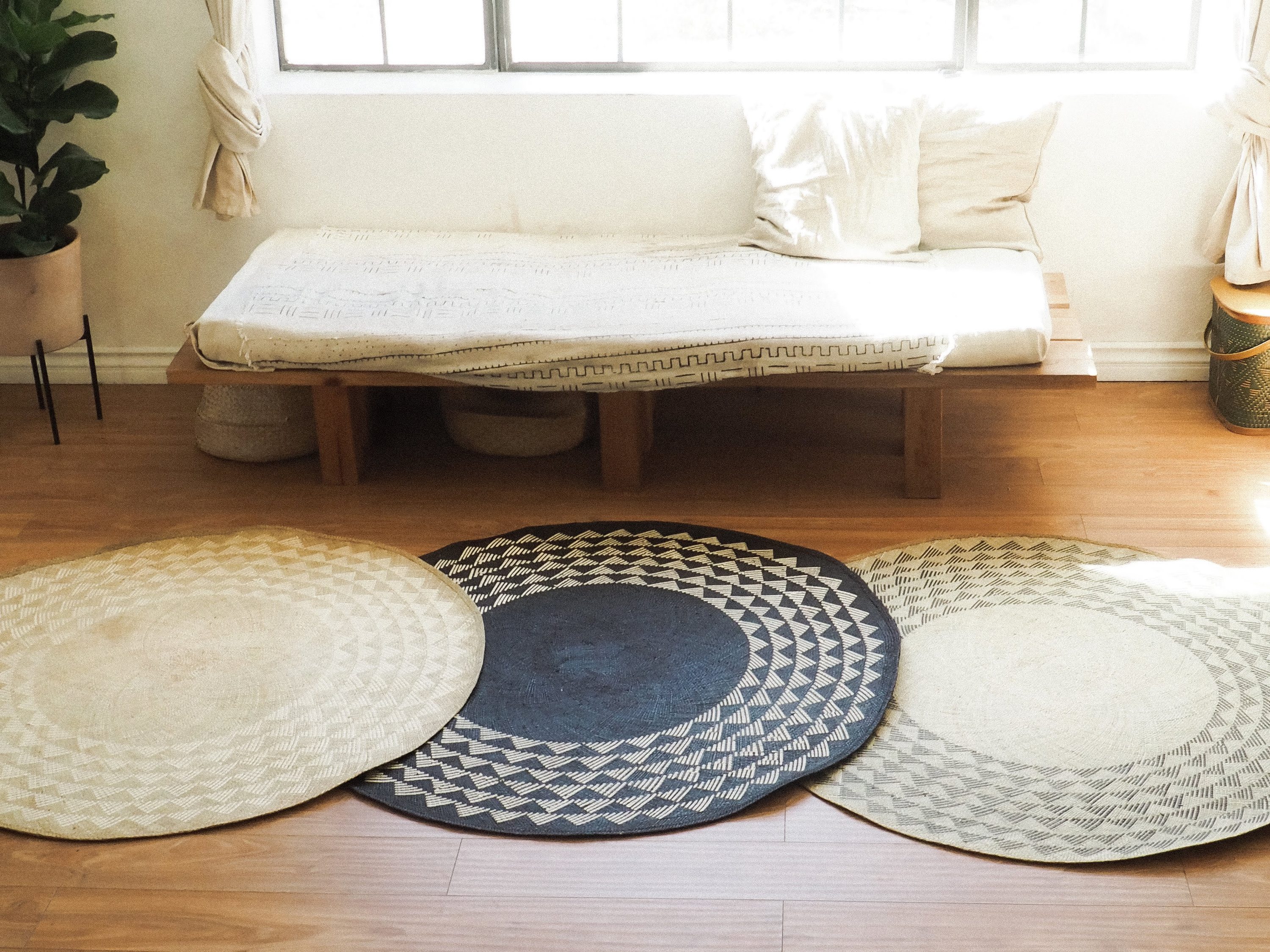 Black Triangle Mat, a 4-foot round rug made from natural fibers with a striking black triangle pattern, perfect for indoor and outdoor use.