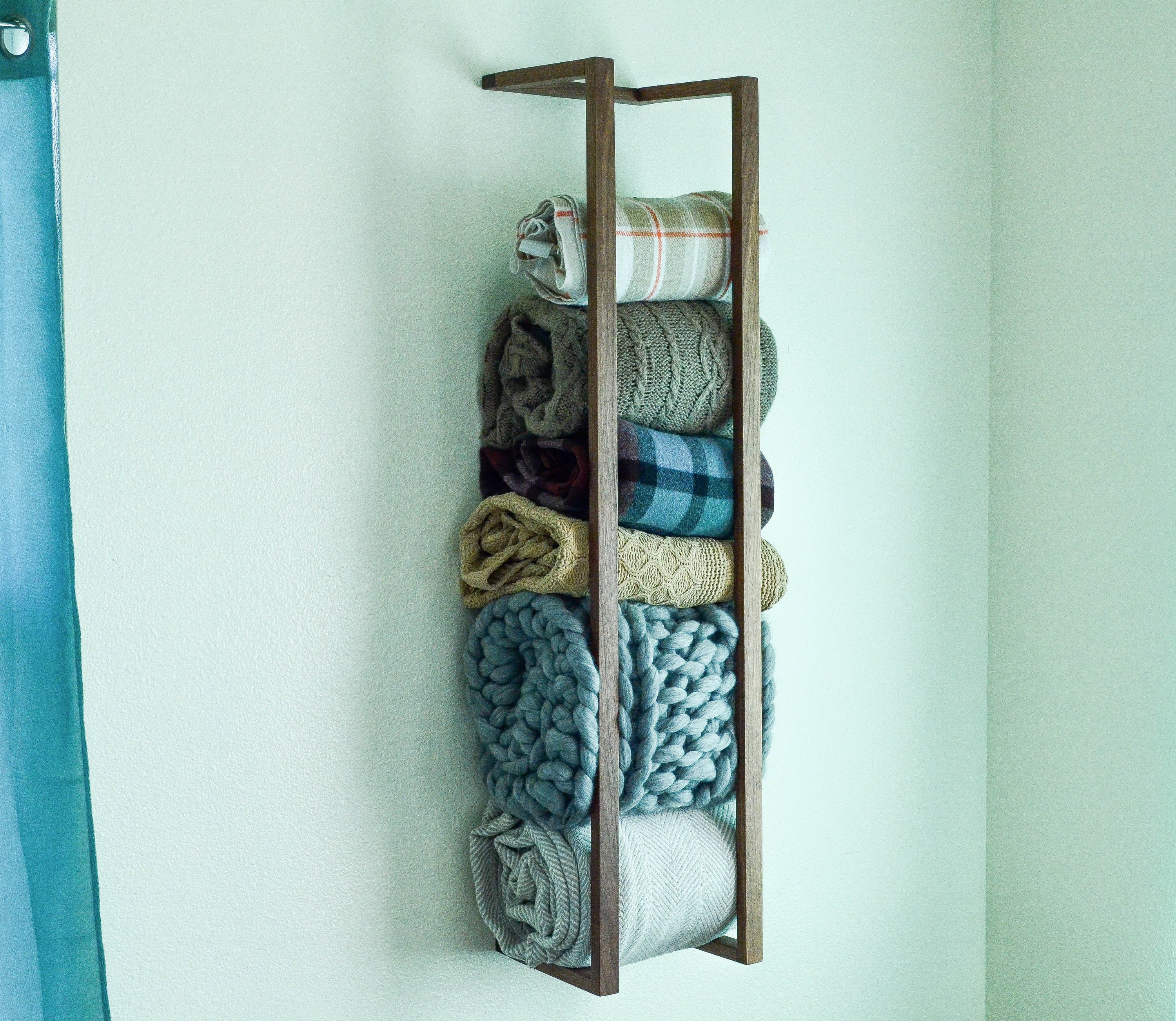 Modern and minimalist blanket wall rack made from American Walnut, showcasing its elegant design and functionality.