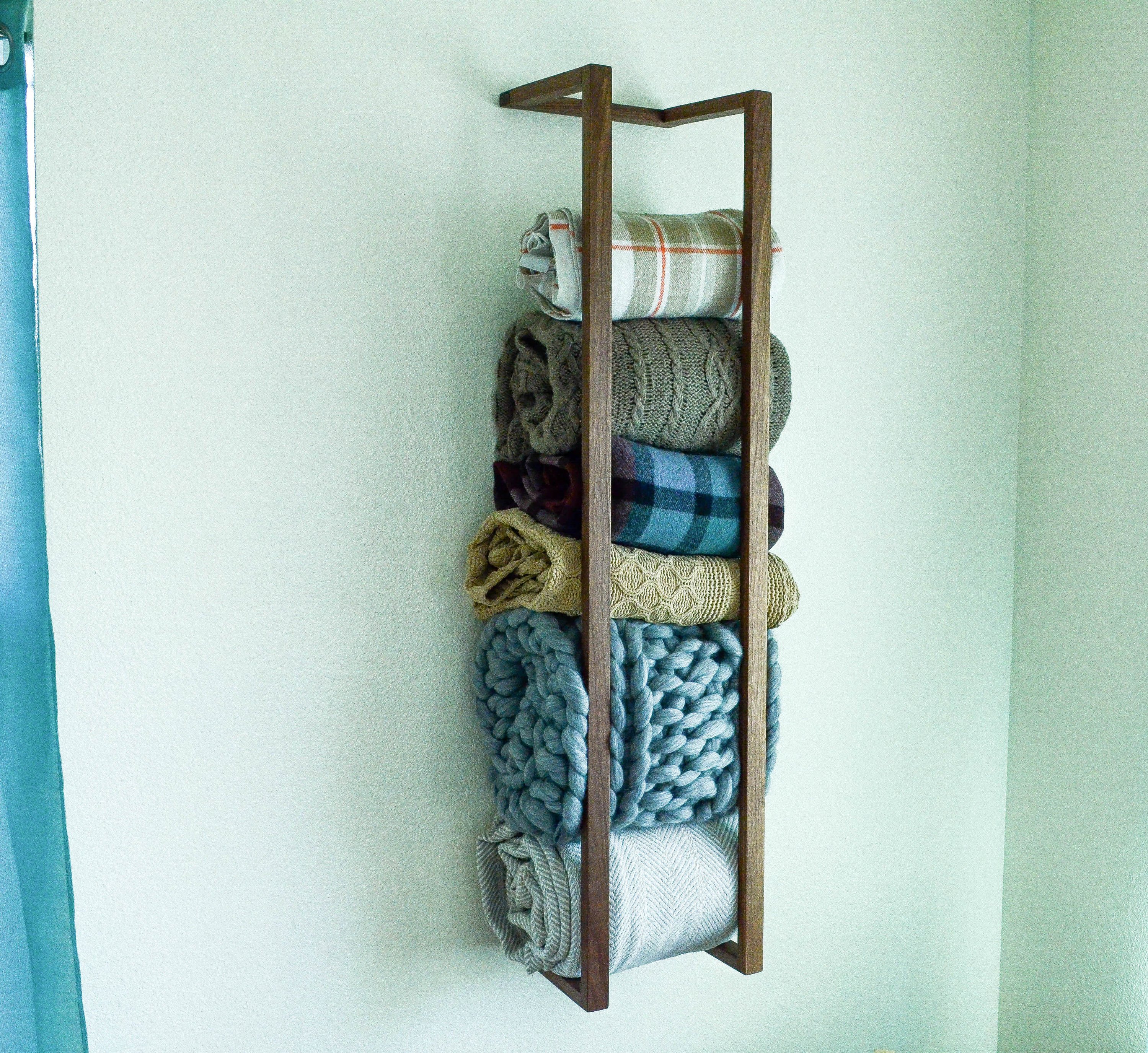 Modern and minimalist blanket wall rack made from American Walnut, showcasing its elegant design and functionality.