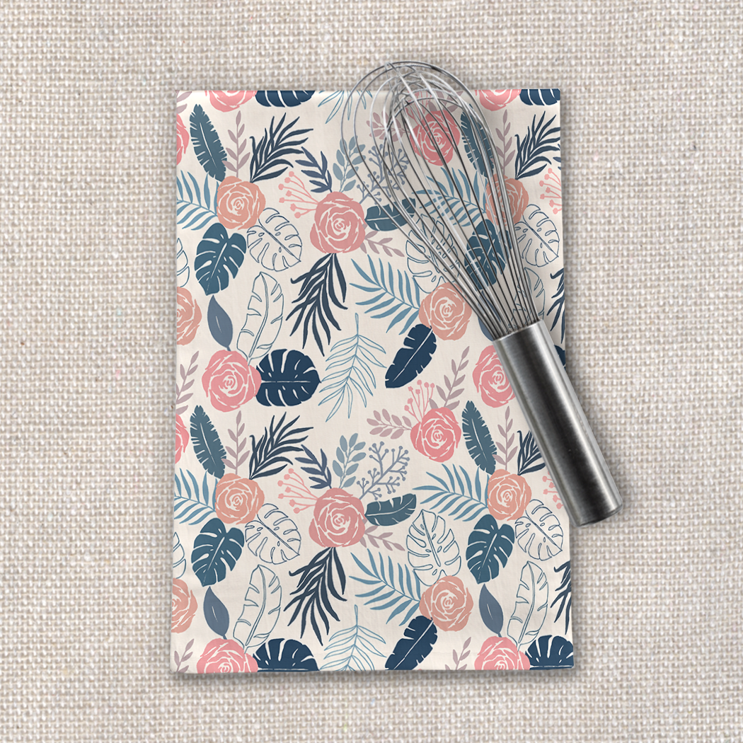 Blue and blush tropical floral tea towel made of cotton twill, featuring a vibrant floral design and hemmed edges, perfect for kitchen use.