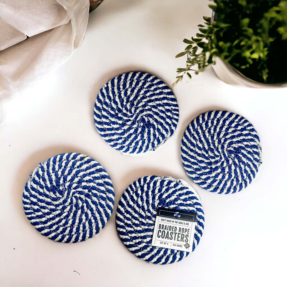 Set of four blue braided coasters with a candy cane stripe pattern, perfect for protecting surfaces and adding festive decor.