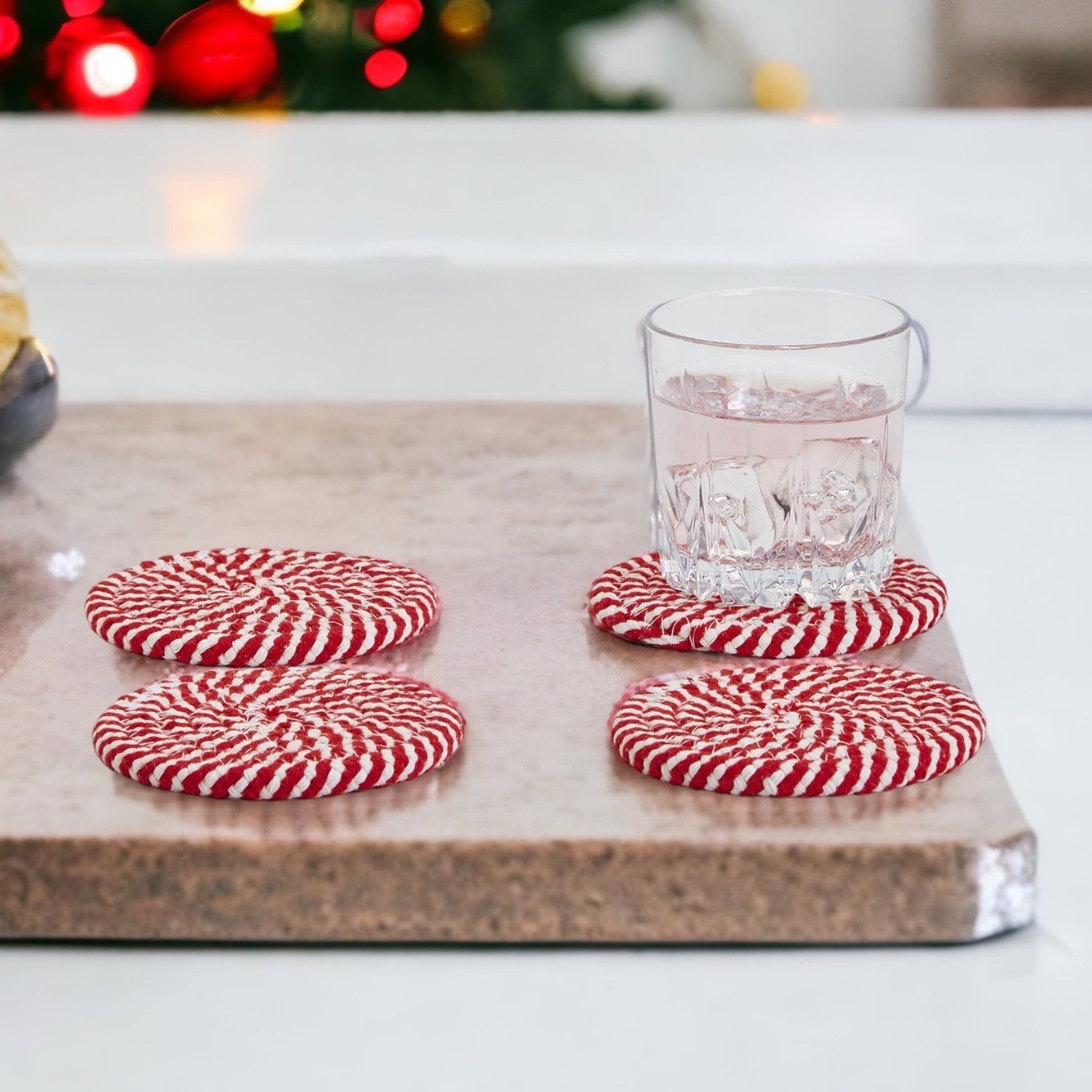 Set of four blue braided coasters with a candy cane stripe pattern, perfect for protecting surfaces and adding festive decor.