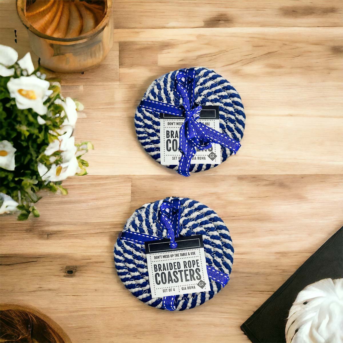 Set of four blue braided coasters with a candy cane stripe pattern, perfect for protecting surfaces and adding festive decor.