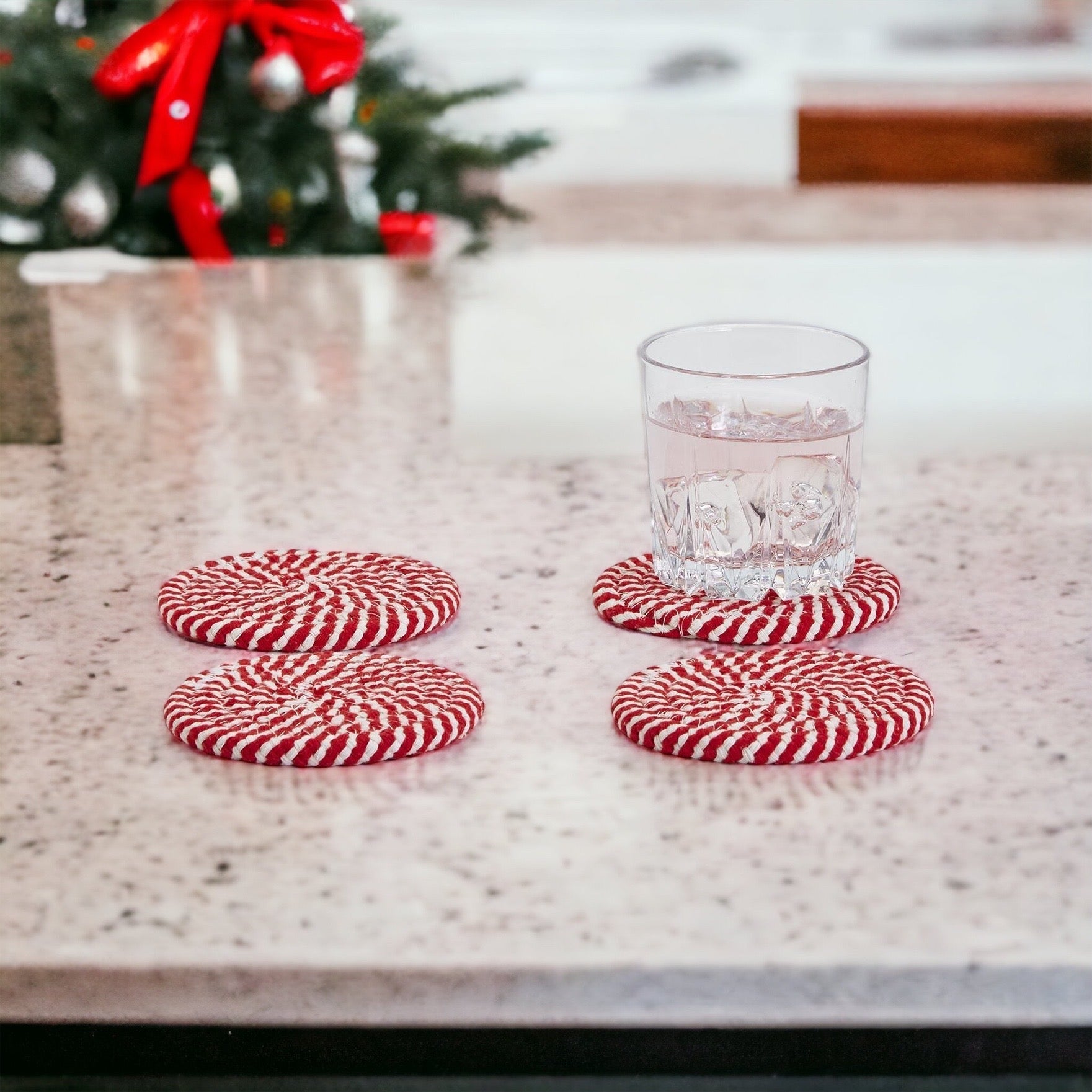 Set of four blue braided coasters with a candy cane stripe pattern, perfect for protecting surfaces and adding festive decor.