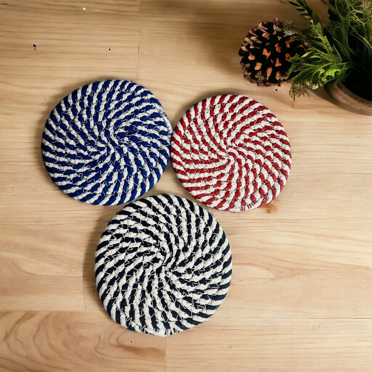 Set of four blue braided coasters with a candy cane stripe pattern, perfect for protecting surfaces and adding festive decor.