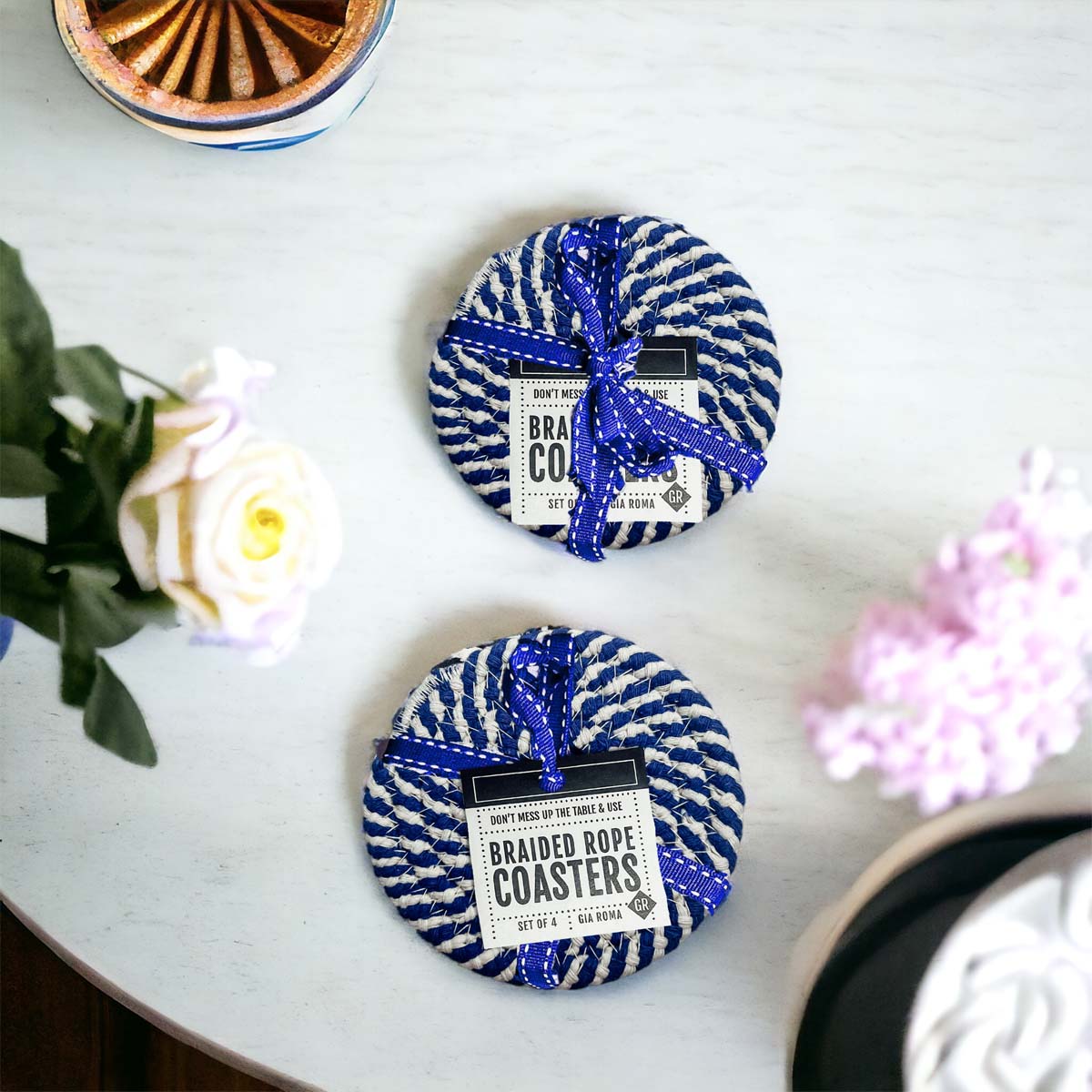 Set of four blue braided coasters with a candy cane stripe pattern, perfect for protecting surfaces and adding festive decor.