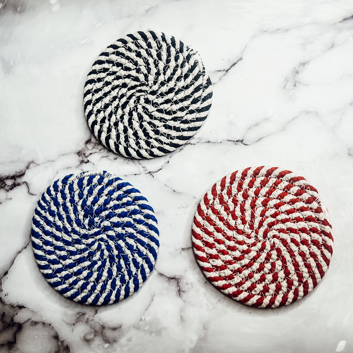 Set of four blue braided coasters with a candy cane stripe pattern, perfect for protecting surfaces and adding festive decor.