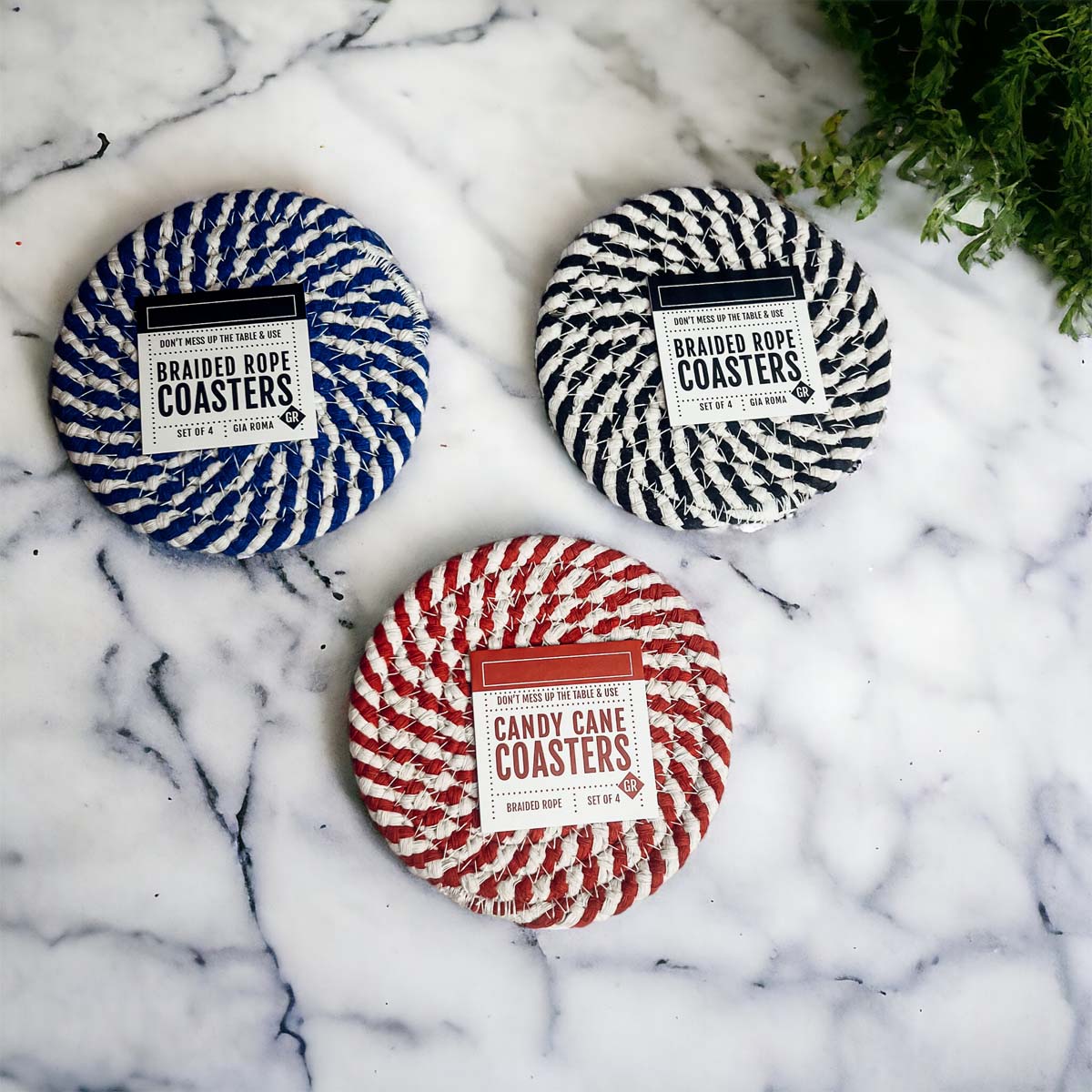 Set of four blue braided coasters with a candy cane stripe pattern, perfect for protecting surfaces and adding festive decor.