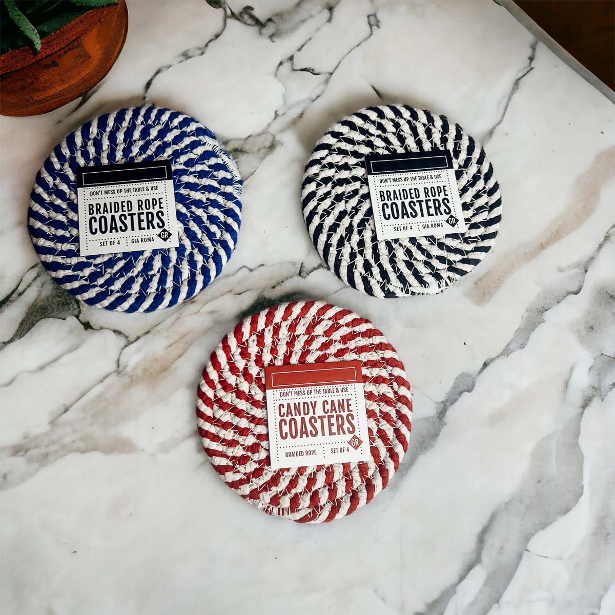 Set of four blue braided coasters with a candy cane stripe pattern, perfect for protecting surfaces and adding festive decor.