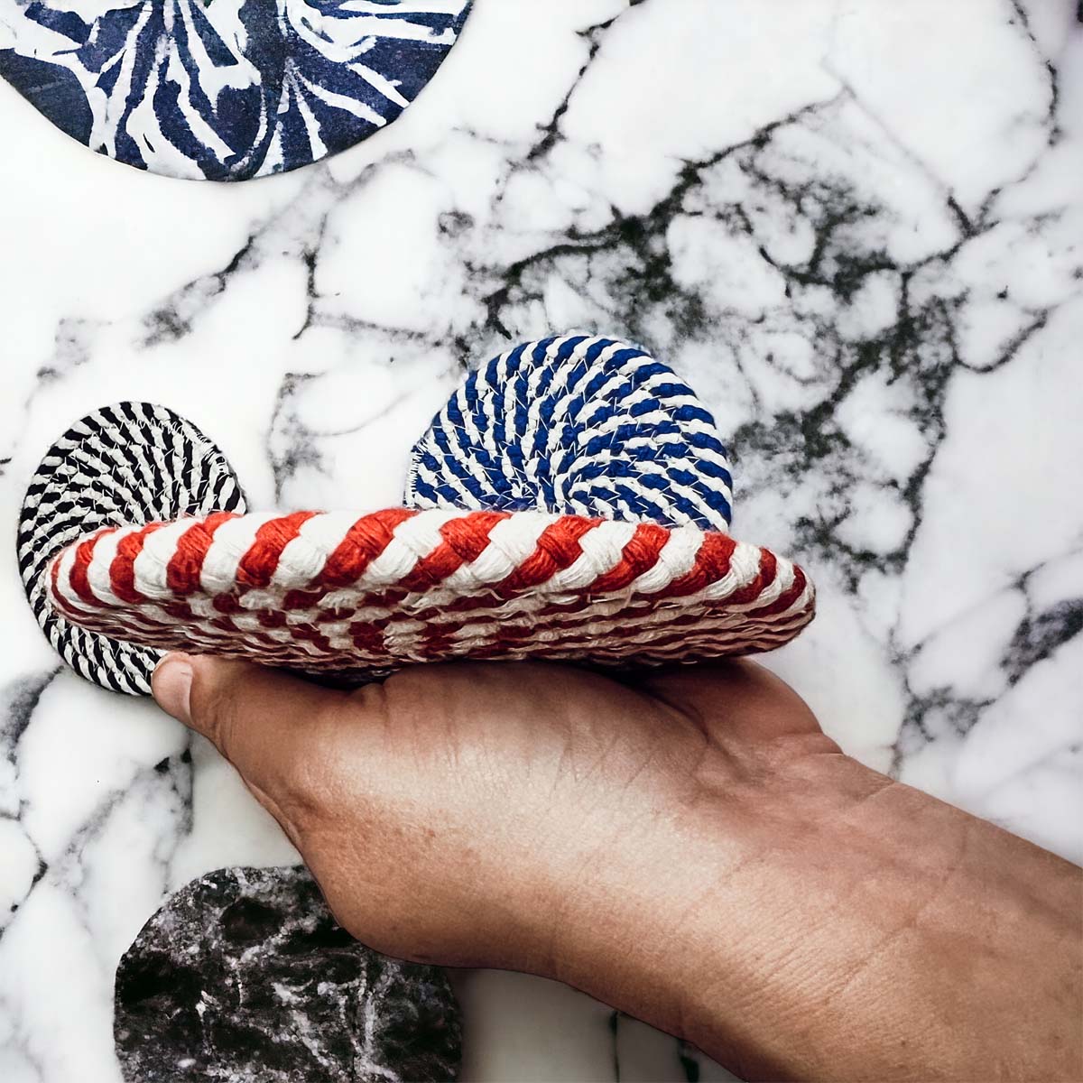 Set of four blue braided coasters with a candy cane stripe pattern, perfect for protecting surfaces and adding festive decor.