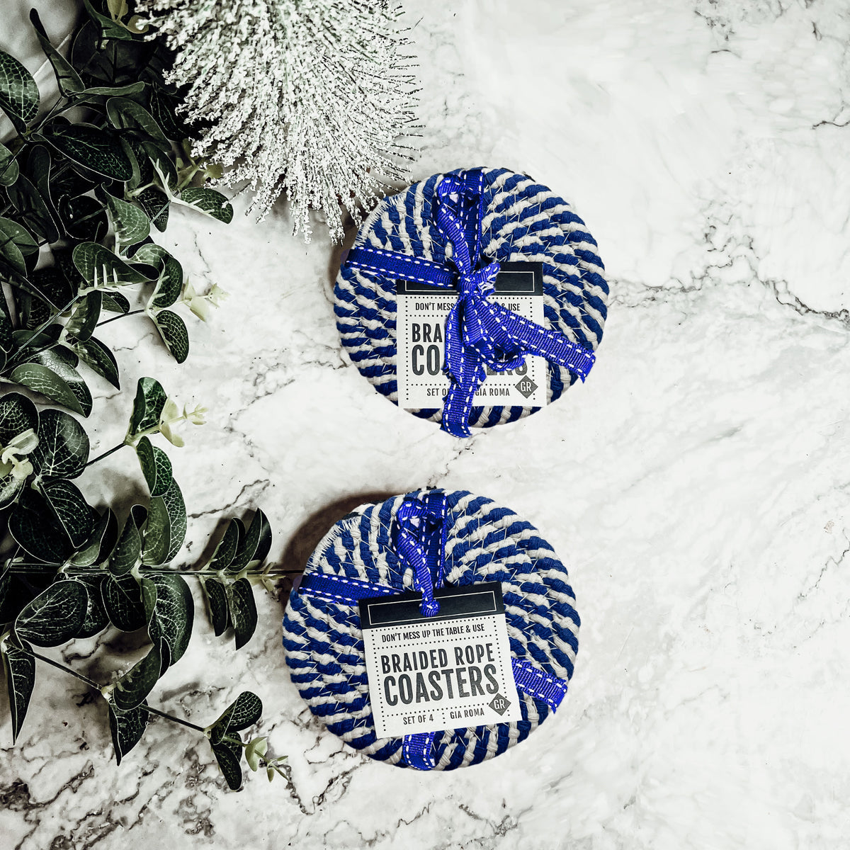 Set of four blue braided coasters with a candy cane stripe pattern, perfect for protecting surfaces and adding festive decor.