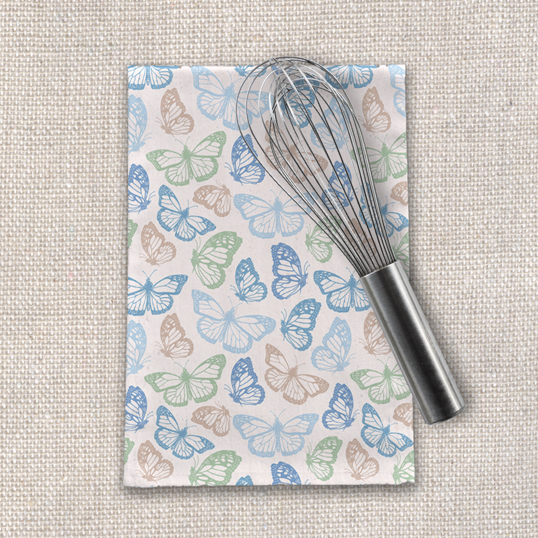 A vibrant blue butterfly tea towel made of cotton twill, featuring a charming butterfly design on a white background, perfect for kitchen decor.