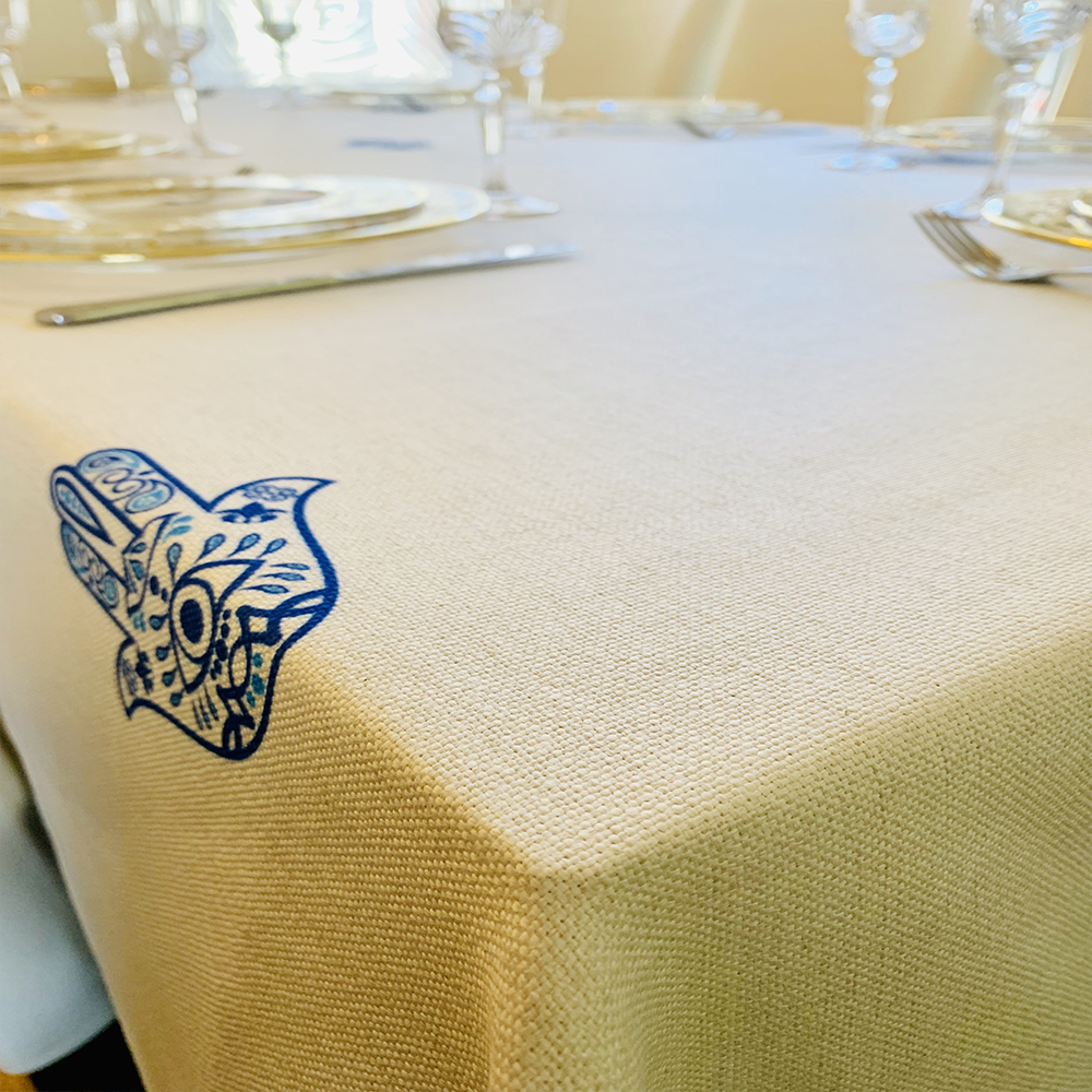 Blue Hamsa Tablecloth featuring an original Ella design by Broderies de France, showcasing a blue-eyed Hamsa symbol.