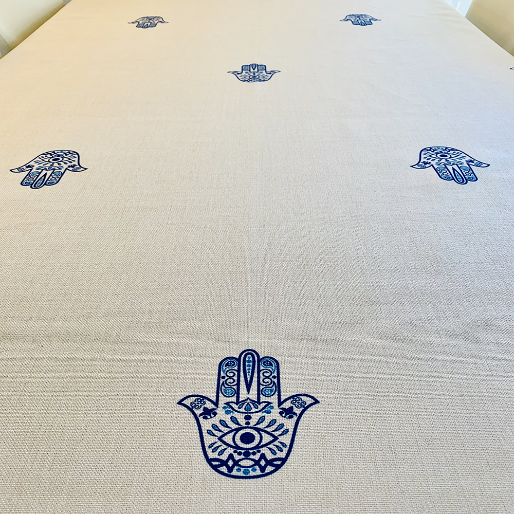 Blue Hamsa Tablecloth featuring an original Ella design by Broderies de France, showcasing a blue-eyed Hamsa symbol.