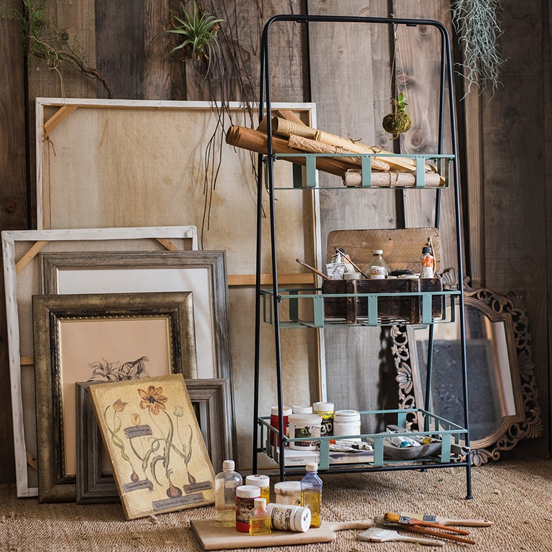 A rustic blue metal shelf with three tiered baskets, showcasing a vintage design perfect for home decor.