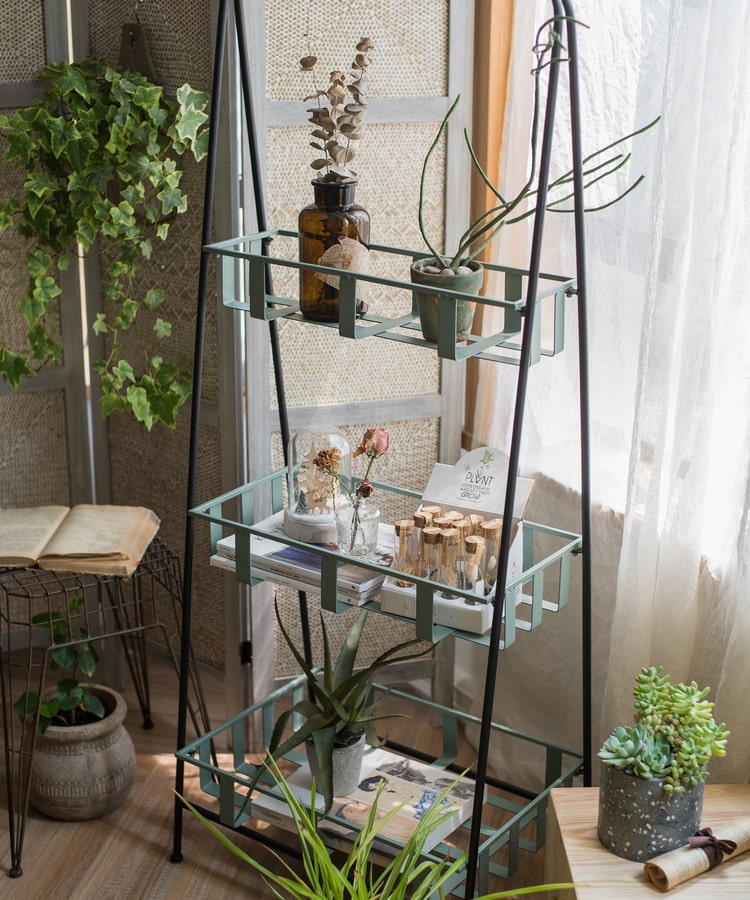 A rustic blue metal shelf with three tiered baskets, showcasing a vintage design perfect for home decor.