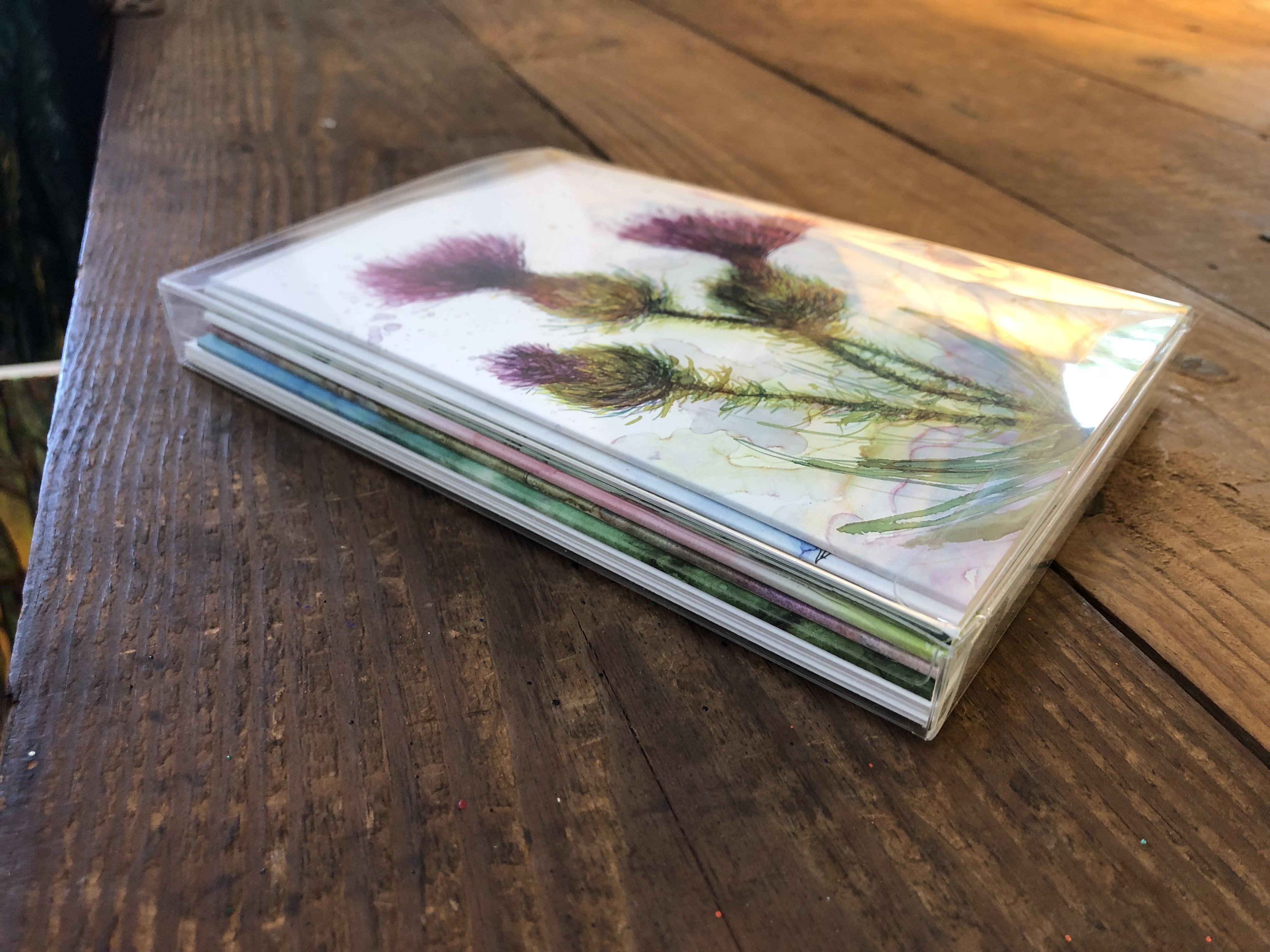 A beautifully arranged box set of 6 greeting cards featuring original flower paintings including Thistles, Daylily, Rose, and Magnolia.