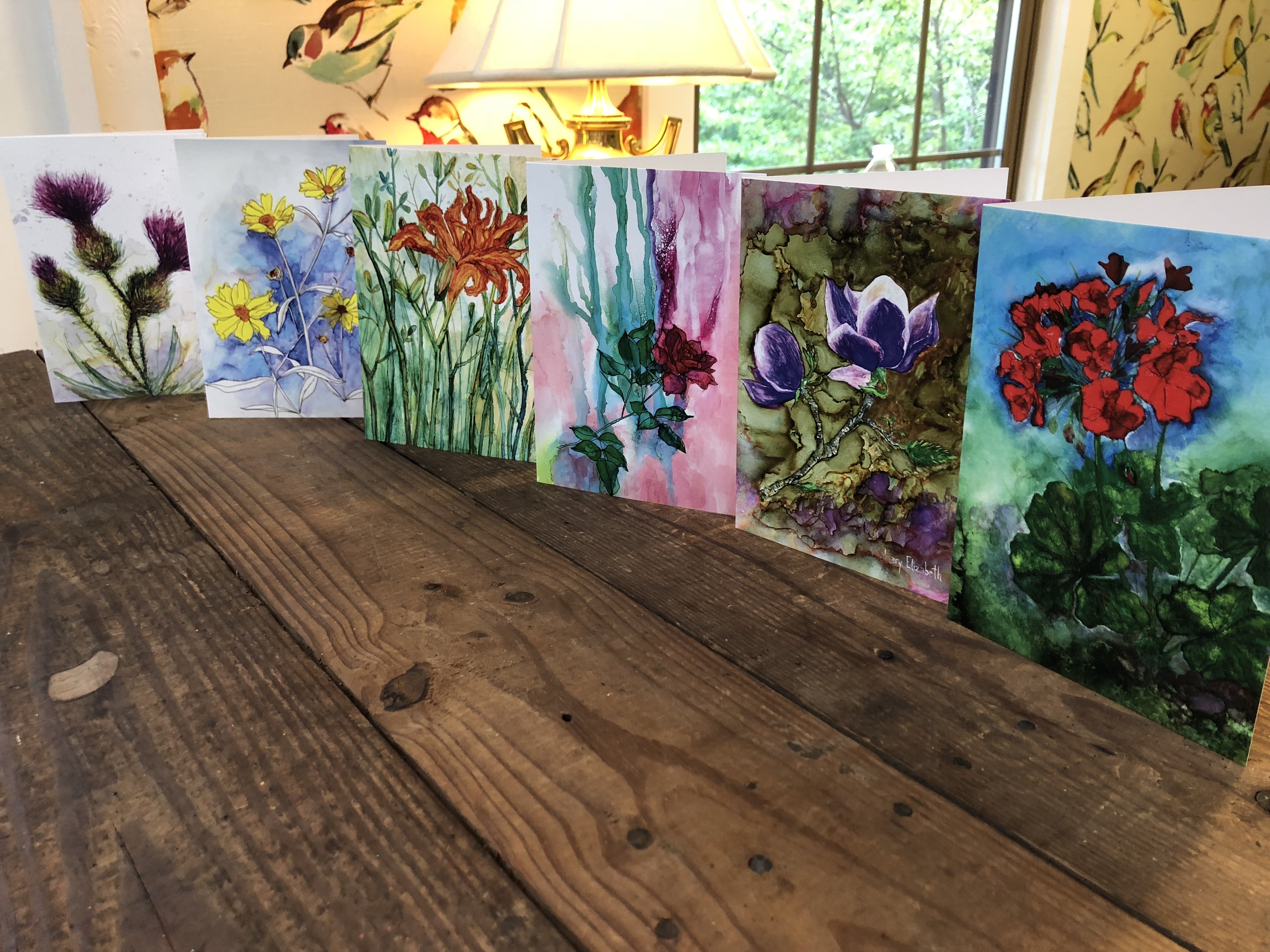 A beautifully arranged box set of 6 greeting cards featuring original flower paintings including Thistles, Daylily, Rose, and Magnolia.