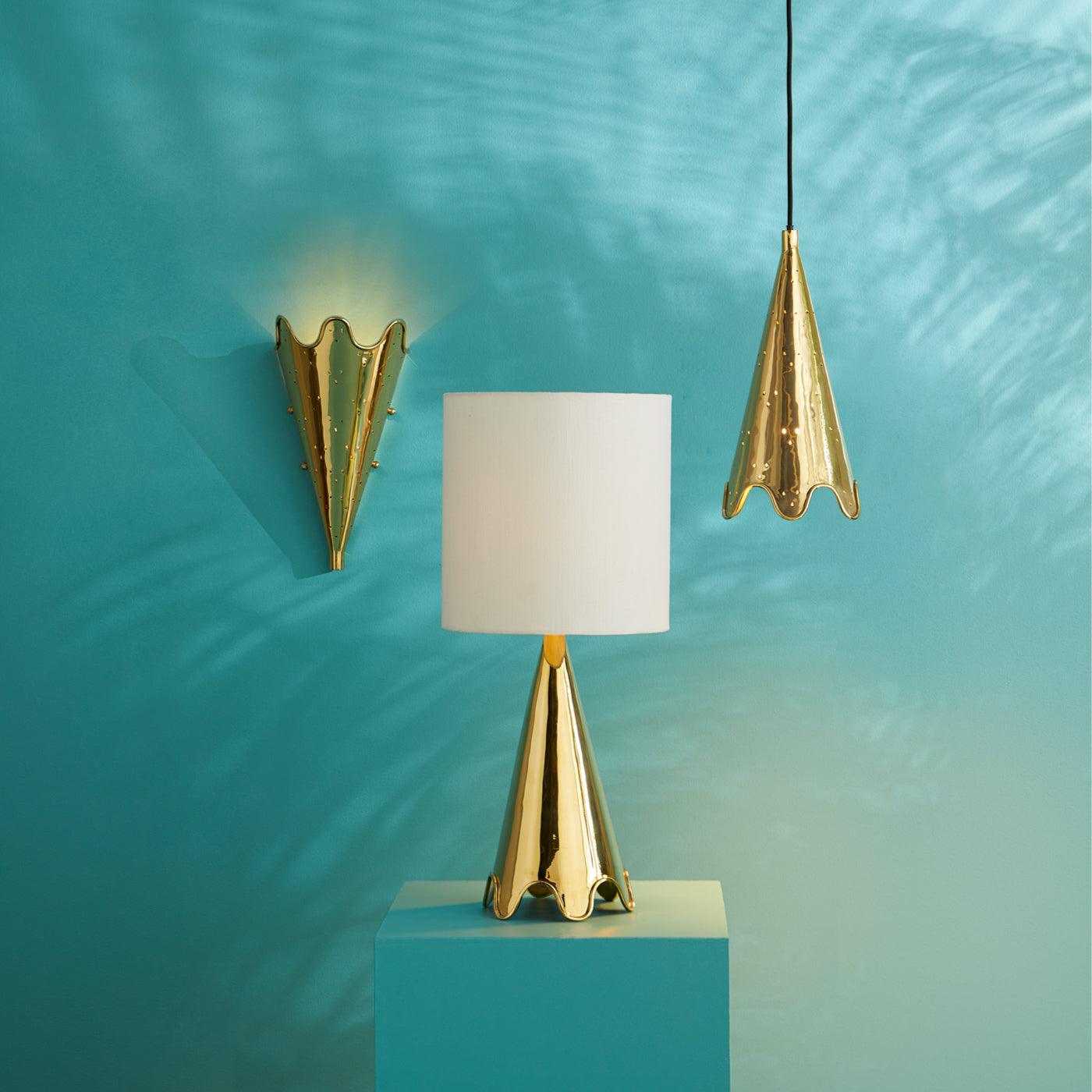 Brass Ripple Torchiere wall sconce with perforated design and polished finish, illuminating a stylish interior.