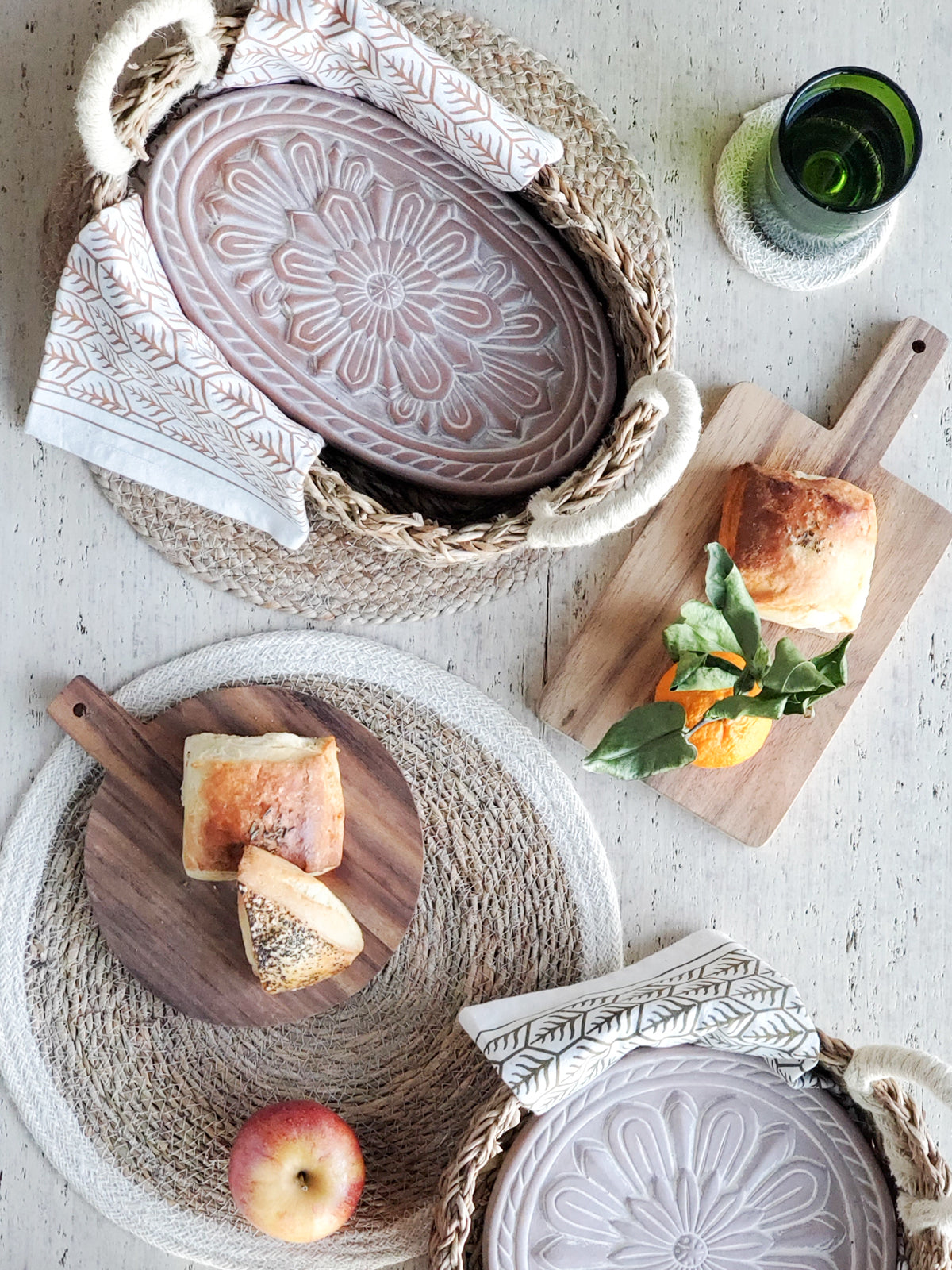 A beautifully crafted Flower Bread Warmer made of terracotta, placed inside a handwoven seagrass basket, showcasing intricate flower engravings.