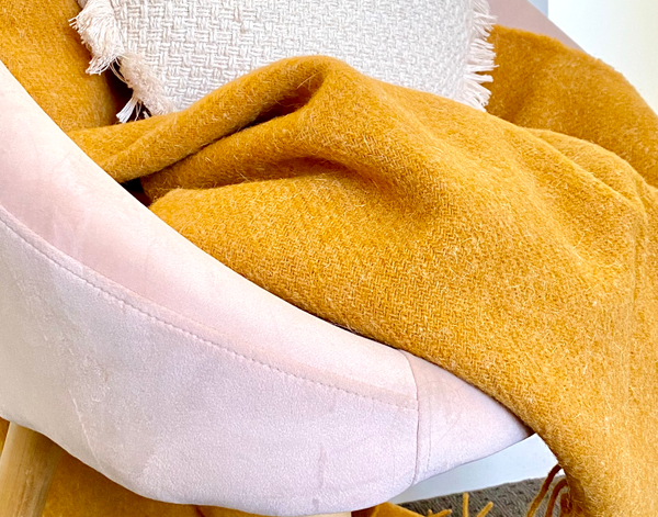 Brighton Throw blanket made from 100% New Zealand wool in mustard color, showcasing its thick and cozy texture.