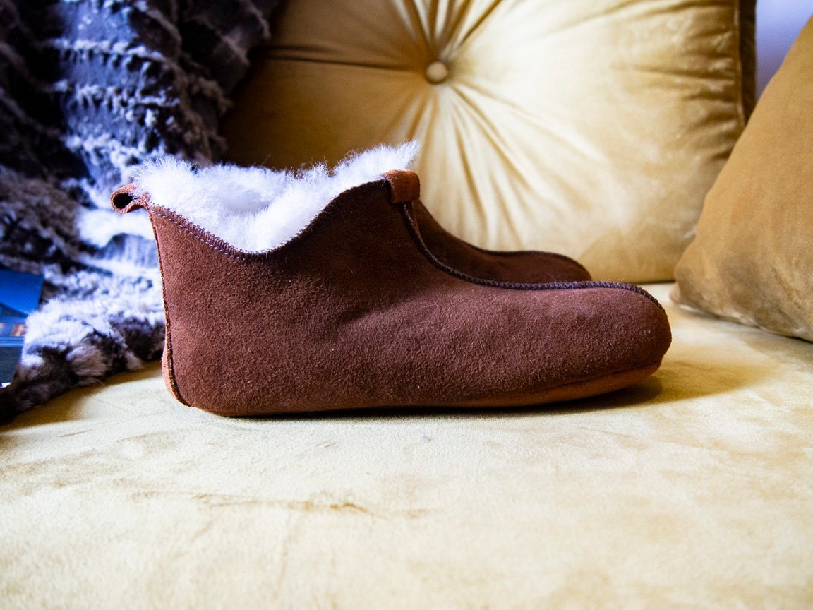 Elegant brown leather slippers with natural fur lining, designed for comfort and durability.