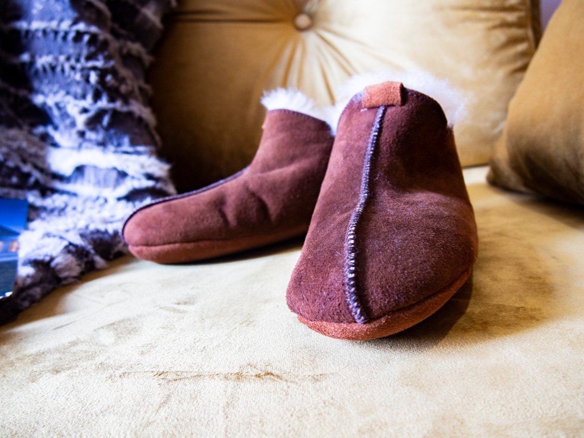 Elegant brown leather slippers with natural fur lining, designed for comfort and durability.