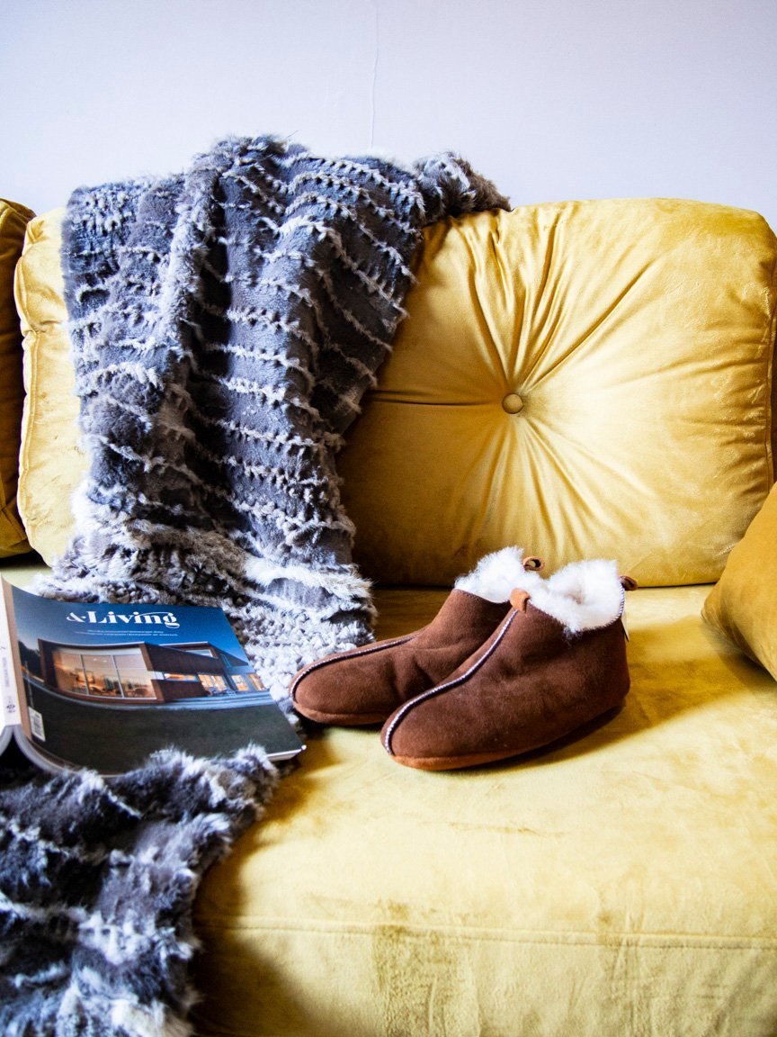 Elegant brown leather slippers with natural fur lining, designed for comfort and durability.