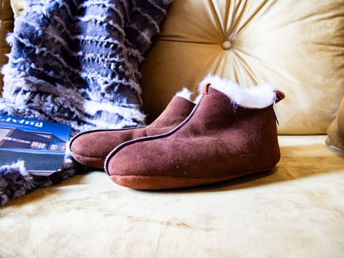 Elegant brown leather slippers with natural fur lining, designed for comfort and durability.