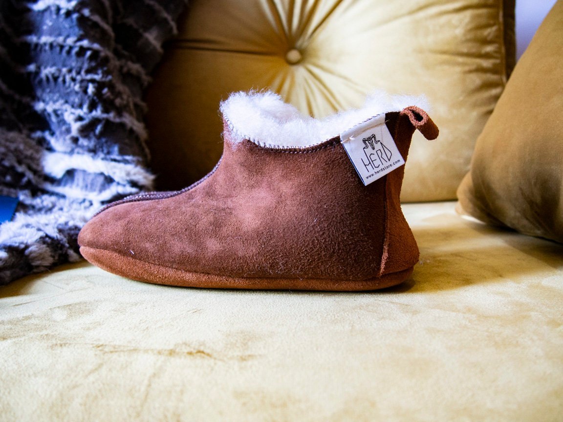 Elegant brown leather slippers with natural fur lining, designed for comfort and durability.